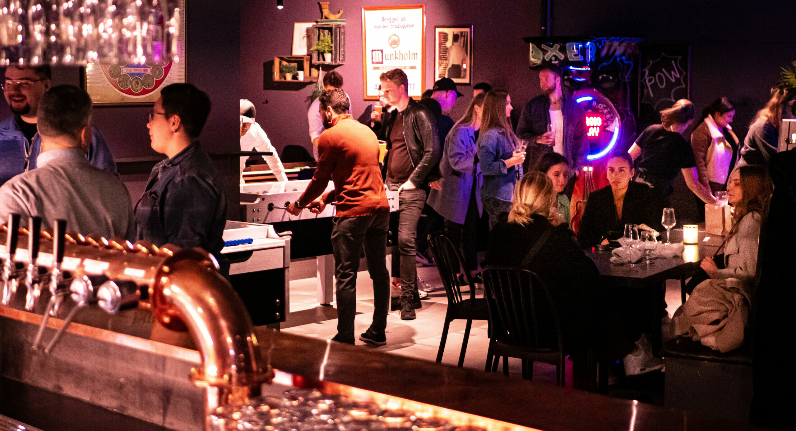 Guests playing table football and talking together at Raadhuset